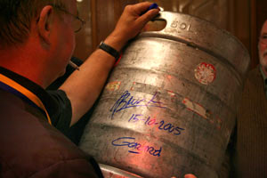 Gerard van den Broek zet een handtekening op biervust